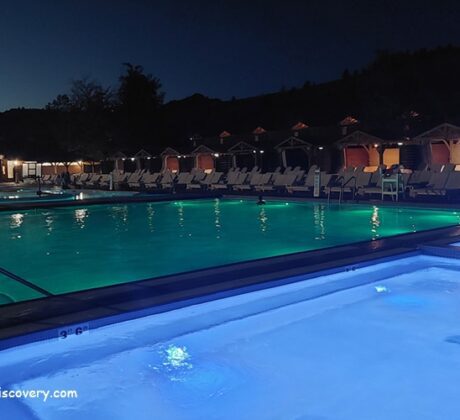 Kah-Nee-Ta Resort and Spa in Oregon: The picture "Kah-Nee-Ta Resort and Spa in Oregon illuminated pools at night" shows the resort's outdoor pools glowing with blue and green lights after dark, surrounded by lounge chairs and cabanas, with the main lodge building softly lit in the background.