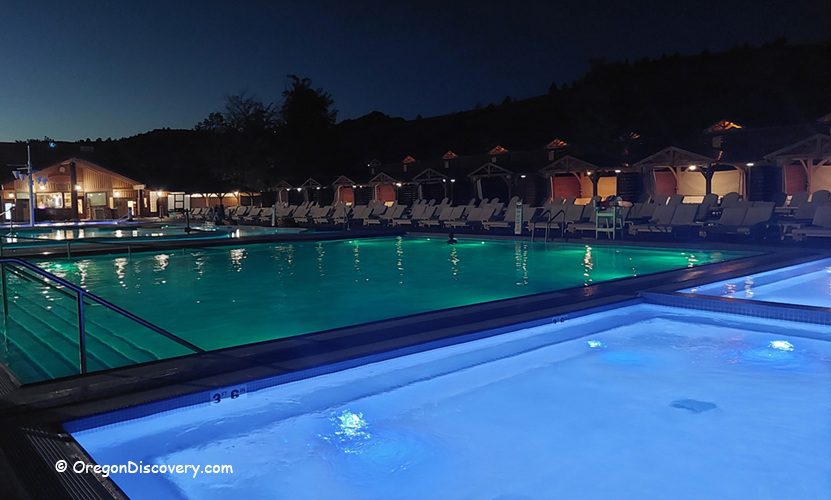 Kah-Nee-Ta Resort and Spa in Oregon: The picture "Kah-Nee-Ta Resort and Spa in Oregon illuminated pools at night" shows the resort's outdoor pools glowing with blue and green lights after dark, surrounded by lounge chairs and cabanas, with the main lodge building softly lit in the background.