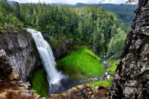 Salt Creek Falls Oregon Hiking: A majestic waterfall, Salt Creek Falls, cascades down a rocky cliff surrounded by lush green vegetation and tall trees, creating a serene and picturesque scene in Oregon.