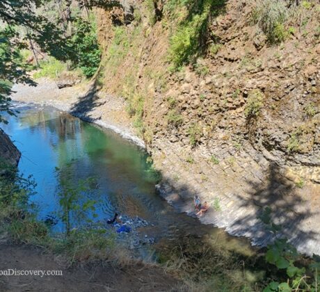 Molalla Eye, Oregon: Scenic Swimming & Fishing Spot on the Molalla River – Molalla Eye Aerial Rim Molalla Eye, Oregon: Scenic Swimming & Fishing Spot on the Molalla River – The picture "Molalla Eye Aerial Rim" is a high perspective shot looking down into the river’s vivid blue-green waters as swimmers relax along the semi-circular stone bank of a narrow, winding canyon.