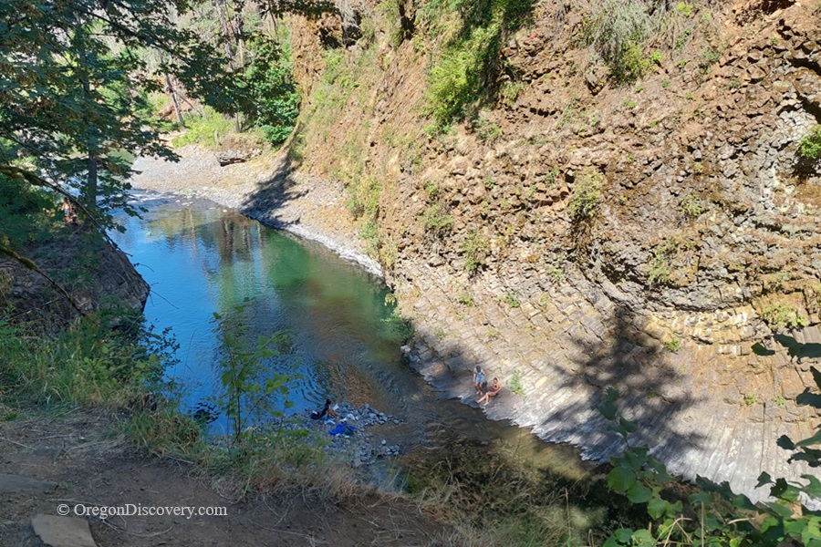 Molalla Eye, Oregon: Scenic Swimming & Fishing Spot on the Molalla River – Molalla Eye Aerial Rim Molalla Eye, Oregon: Scenic Swimming & Fishing Spot on the Molalla River – The picture "Molalla Eye Aerial Rim" is a high perspective shot looking down into the river’s vivid blue-green waters as swimmers relax along the semi-circular stone bank of a narrow, winding canyon.